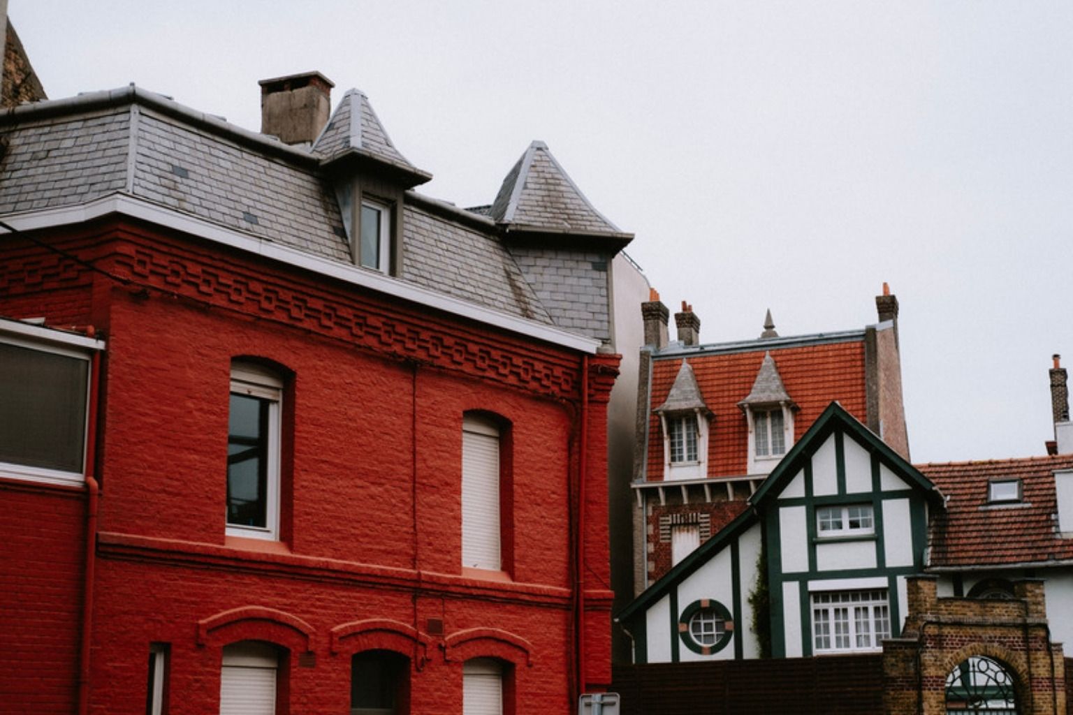 Røde murstenshuse med grå skifertage, kviste og skorstene